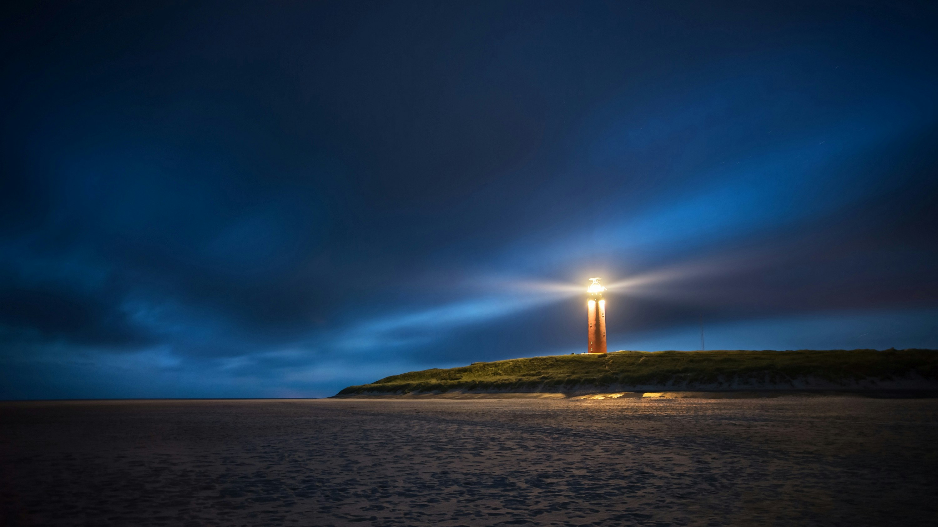 lighthouse under cloudy sky during nighttime